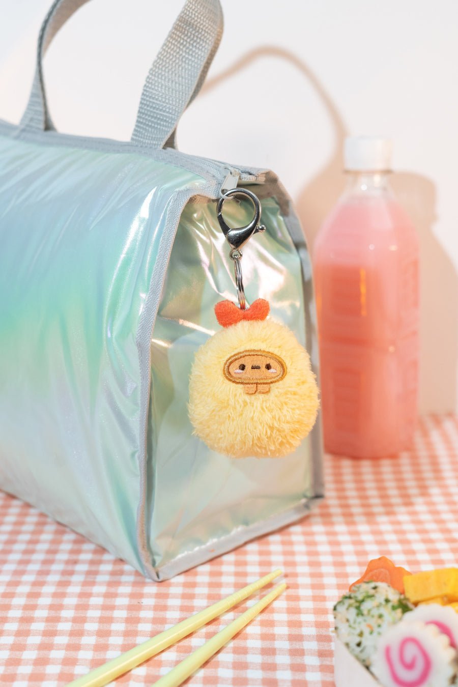 Clear bag with a plush toy keychain on a checkered tablecloth