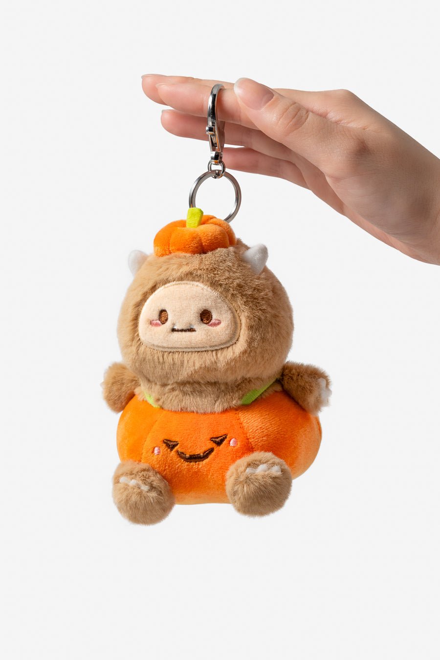 Plush keychain shaped like a bear in an orange costume with a pumpkin on a white background
